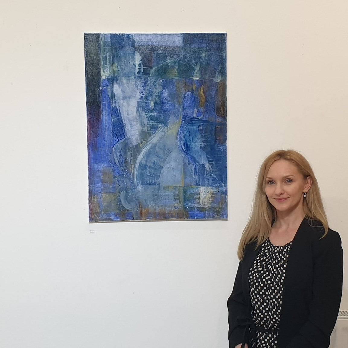 Paulina Pawlik standing next to her painting Awakening