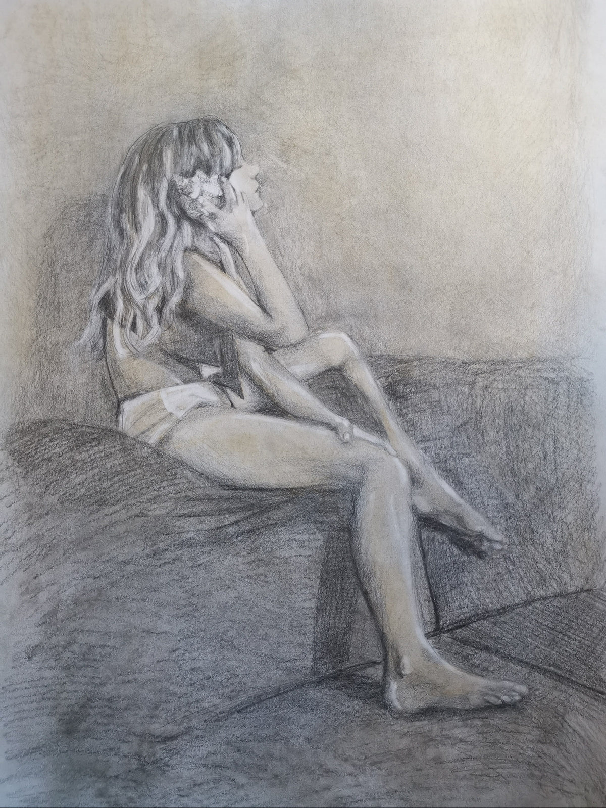 Pencil drawing of a person sitting on a couch with a flower in their hair.